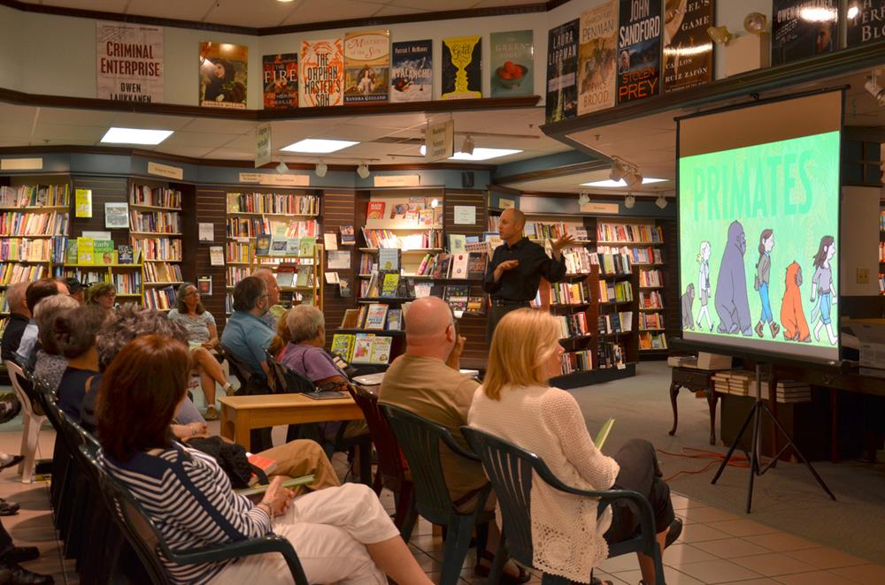 A literary event inside a library, where an author is talking about his book in front of an audience